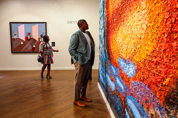 Man looking at vibrant art in museum gallery