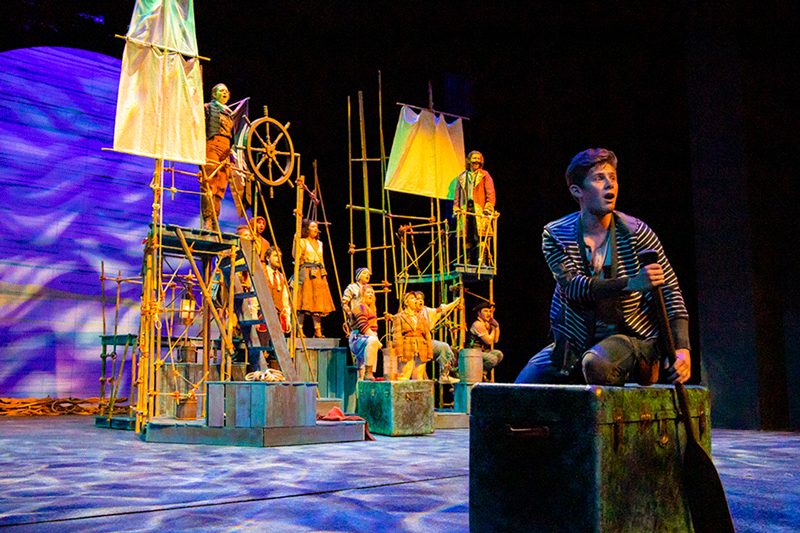 Students on the set of a pirate ship amidst dark blue lighting