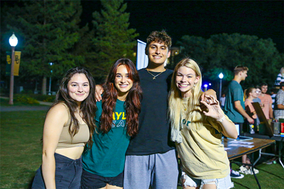 Baylor students smiling together at nighttime  event